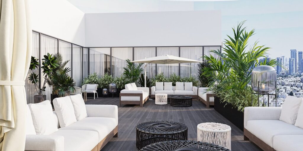 מרפסת גג מעוצבת עם ספות לבנות, שולחנות קפה, צמחייה עשירה ונוף עירוני ברקע.